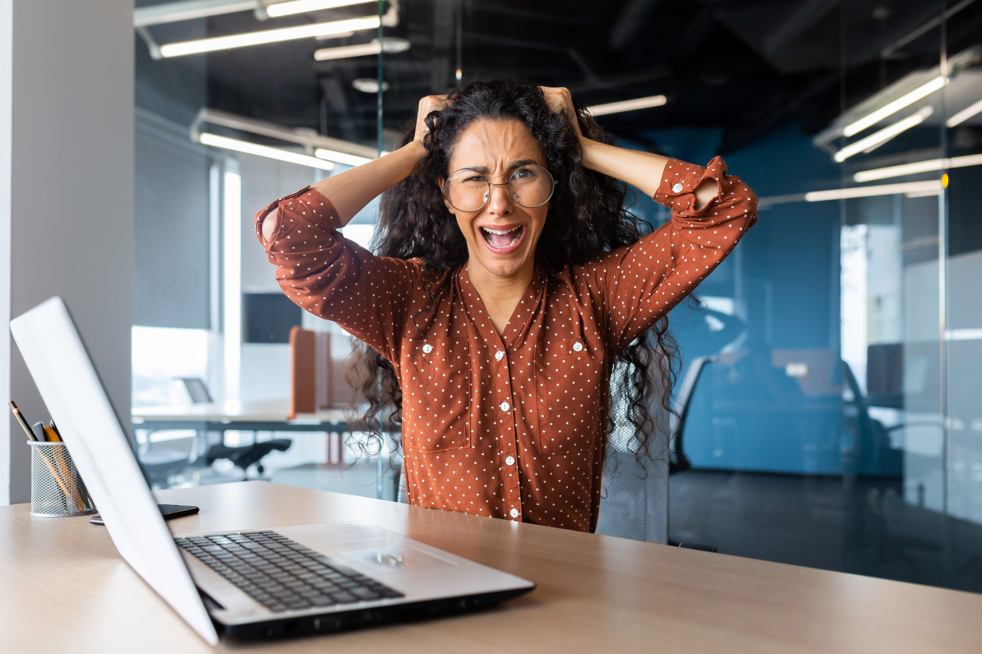 Frustrated woman with laptop in office